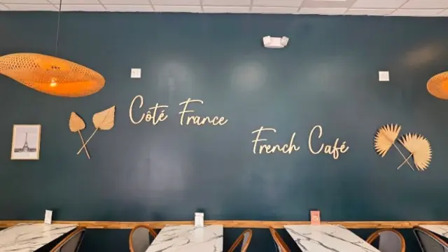La salle du Côté France French Café à Tampa, enseigne murale et tables en marbre